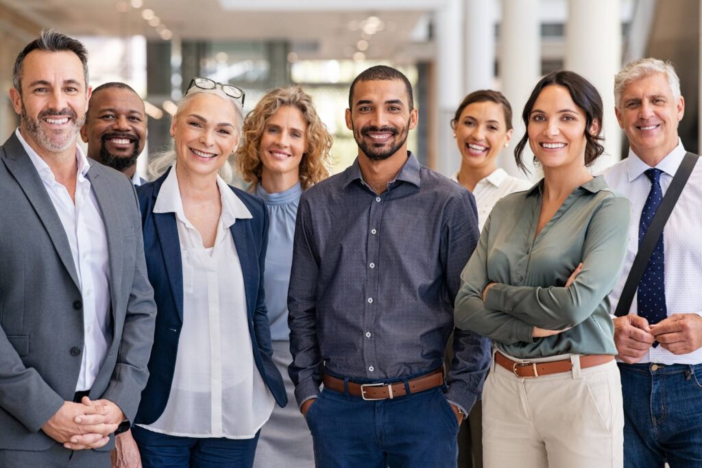 Large group of men and women, standing proudly, smiling because they have graduated from the Mars Venus Coaching Coach certification program